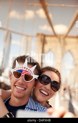 Paar in Neuheit Sonnenbrille Aufnahme auf städtische Brücke Stockfoto
