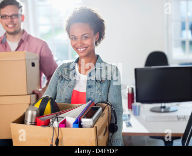 Geschäftsfrau mit Kasten von Gegenständen Stockfoto