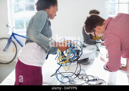 Geschäftsleute entwirren Schnüre im Büro Stockfoto