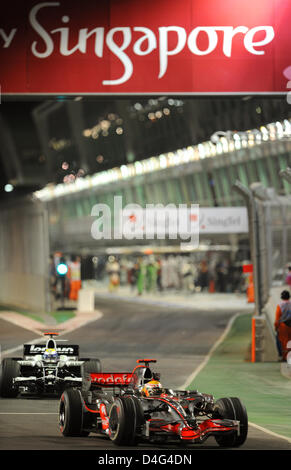 Britische Formel1-Fahrer Lewis Hamilton von McLaren Mercedes (vorne) und deutsche Formel1-Fahrer Nico Rosberg Williams-Toyota verlassen (wieder) die Boxengasse im Qualifying am Marina Bay Street Circuit in Singapur, Singapur, 26. September 2008. Singapur wird am 28. September 2008 Formel1 Straße erste Nacht-Grand Prix-Rennen veranstalten. Foto: Frank Mai Stockfoto