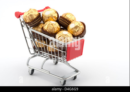 Einkaufswagen voller Schokolade auf weißem Hintergrund Stockfoto
