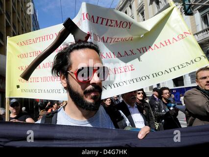 Ein Mann mit einer Axt-Mock-up auf dem Kopf trägt einen Banner während einer Protestaktion durch Museumsmitarbeiter Kulturministerium in Athen, Griechenland, 13. März 2013. Staatliche Museen und archäologischen Stätten werden bis 19. März 2013 wegen Streiks durch Museumsmitarbeiter geschlossen. Die Proteste richten sich gegen die Umstrukturierung der Verwaltung der Kulturpolitik. Foto: Michael Anhaeuser Stockfoto