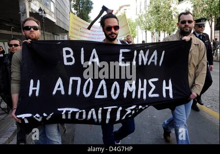 Ein Mann mit einer Axt-Mock-up auf dem Kopf trägt einen Banner während einer Protestaktion durch Museumsmitarbeiter Kulturministerium in Athen, Griechenland, 13. März 2013. Staatliche Museen und archäologischen Stätten werden bis 19. März 2013 wegen Streiks durch Museumsmitarbeiter geschlossen. Die Proteste richten sich gegen die Umstrukturierung der Verwaltung der Kulturpolitik. Foto: Michael Anhaeuser Stockfoto