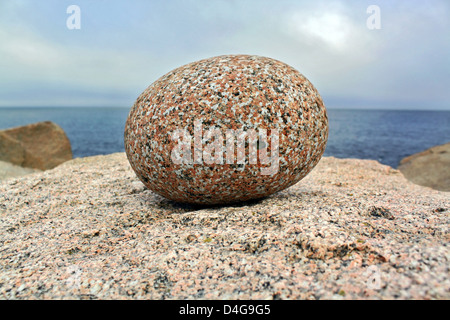 Runde grainny Stein an der Atlantik-Küste mit Wolken im Hintergrund Stockfoto