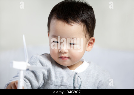 Niedlichen kleinen Jungen spielen Papier Windmühle Stockfoto