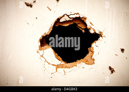 Loch in die Faserplatten auf schwarzem Hintergrund. Stockfoto