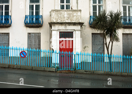 Verfallenes Haus mit Brettern vernagelt Windows in Guernsey Stockfoto