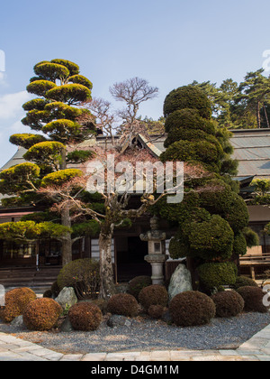 Garten mit Steinlaterne und Niwaki beschnitten Pflanzen vor dem Eingang zu einem buddhistischen Tempel in Koyasan, Japan. Stockfoto