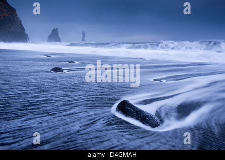 Wellen über schwarzen Sandstrand in der Nähe von Vik auf der südlichen Küste von Island. Winter (Januar) 2013. Stockfoto