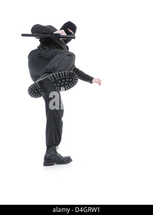 Anti-Terror-Polizei Mann trug schwarzen Uniformen und schwarzen Maske machen einen Side-Kick, geschossen auf weiß Stockfoto