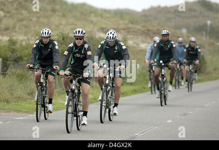 Spieler der Bundesliga club Werder Bremen, Frank Baumann (L) und Daniel Jensen (vorne), fahren ihre Fahrräder während des Trainings auf Osten Ostfriesischen Insel Norderney, Deutschland, 15. Juli 2008. Das Team setzt seine erste Trainingseinheit vor der Fußball-Saison 2008/09 bis 20 Juli. Foto: CARMEN JASPERSEN Stockfoto