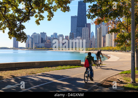 Radfahrer fahren entlang Lake Michigan mit der Skyline von Chicago über Chicago, Illinois, USA Stockfoto