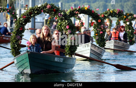 Ruderboote mit Blumenkränzen geschmückt kommen am Hafen von Radolfzell am Bodensee, Deutschland, 21. Juli 2008. Einige 20 Boote nahmen an der diesjährigen "Mooser Wasserprozession" (wörtlich: "Moos Wasser Prozession"). Der Umzug erfolgte am Bodensee zum ersten Mal im Jahre 1926. Jeden dritten Montag im Juli Moos Bürger gedenken, dass ihre Stadt verschont wurde ein Stockfoto