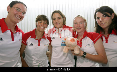 Deutsche internationale Fußball-Spieler, Nadine Angerer, Conny Pohlers, Birgit Prinz (L-R), Ariane Hingst und Ursula Holl posieren mit einem Glücksschwein vor ihrer Abreise nach Peking, am Flughafen in Frankfurt Main, Deutschland, 30. Juli 2008. Einige 80 Mitglieder der Ruder Nationalmannschaft und die Frauen-Fußball-Nationalmannschaft wurden offiziell von Vertretern des DOSB (Deutsche Olympische Sp aus gesehen Stockfoto