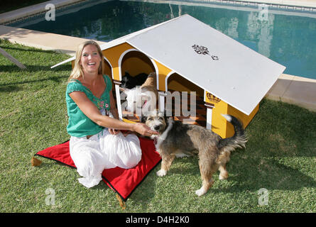 Maja Synke Prinzessin von Hohenzollern posiert mit ihren Hunden "Josy" (R) und "Bambi" vor eine Hundehütte entworfen von sich selbst in einem Garten in Marbella, Spanien, 26. Juli 2008. Maja von Hohenzollern lebt in einem Haus in Andalusien mit fünf Welpen, fünf Hunde und zwei Katzen, die sie von der Straße oder der Tötung Station gerettet hat. Maja von Hohenzollern verkauft ihre aufwändig gestaltete ani Stockfoto