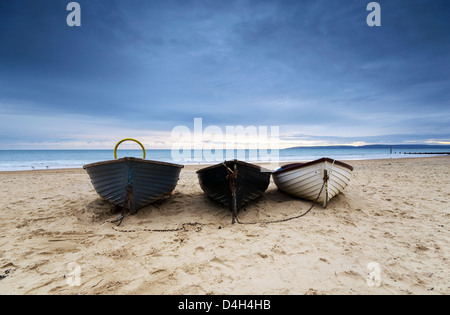 Angelboote/Fischerboote unter einem grüblerischen Himmel bei Durley Chine am Strand von Bournemouth. Stockfoto