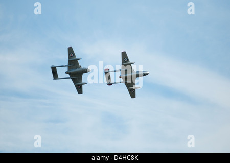 Zwei kleine Jets fliegen in enger Formation, von unten gesehen. Stockfoto