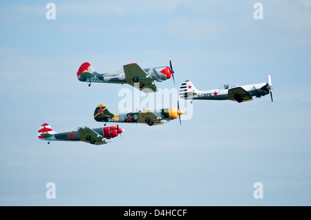 Vier bunte kleine Flugzeuge fliegen in Formation schließen Stockfoto