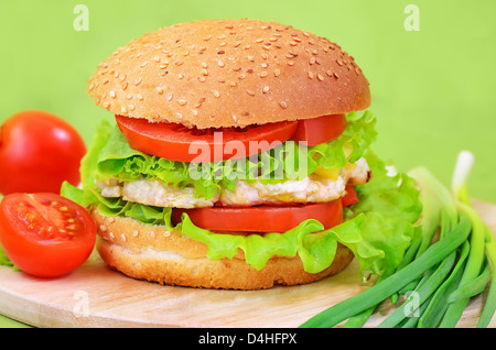 Burger-Fast-Food auf einem Brett Küche mit Tomaten und Frühlingszwiebeln Stockfoto