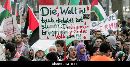 Menschen protestieren mit einem Banner lesen? Die Welt ist taub, die Welt ist stumm... Die Monster zu töten, ein ganzes Volk? während einer Kundgebung gegen die israelischen Angriffe auf den Gaza Streifen Sie in Düsseldorf, 3. Januar 2009. Mehr als 3.000 Demonstranten versammelten sich zu einer sofortigen Beendigung der Israel? s Militäraktion, Wiedereröffnung des Randes und sofortige Friedensverhandlungen. Foto: ROLAND WEIHRAUCH Stockfoto