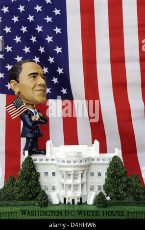 Eine Gestalt des designierten Präsidenten Barack Obama steht auf einem Modell des weißen Hauses vor einer US-Flagge in Berlin, Deutschland, 13. Januar 2009. Obama wird zum 44. US-Präsidenten am 20. Januar in Washington D.C., USA eröffnet. Obama der erste afroamerikanische Präsident werden und ist ein beliebtes Motiv für waren. Foto: RAINER JENSEN Stockfoto