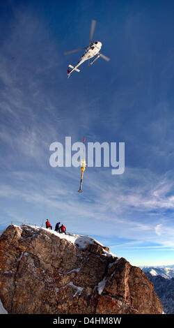 Ein Hubschrauber entfernt die? Zugspitze? (2962m) Gipfelkreuz in der Nähe von Grainau, Deutschland, 26. Januar 2009. Die fast 5m hoch und 300kg schwere Eiserne Kreuz wird renoviert und soll bis auf die Gipfel rund um Ostern 2009 neu installiert werden. Foto: Karl-Josef Hildenbrand Stockfoto