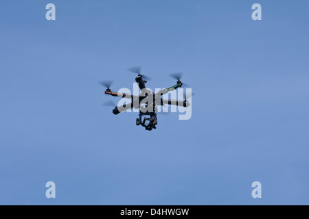 Entfernten ferngesteuerten Hubschrauber mit einer kleinen Videokamera fliegt vor einem blauen Himmel. Stockfoto