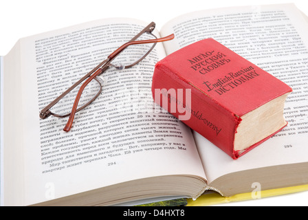 Das kleine rote Wörterbuch legt auf das geöffnete Buch Stockfoto