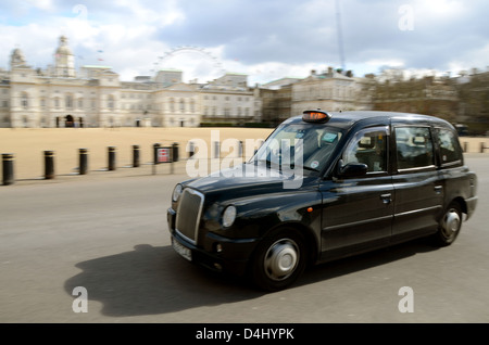 Ein schwarzes Londoner Taxi passiert die Horse Guards Parade mit Bewegungsunschärfe. Britisches Symbol Stockfoto