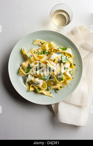 Ein Teller mit Pappardelle Pasta mit cremigem Ricotta, Baby-Spinat, frischen Kräutern und Pfeffer. Stockfoto