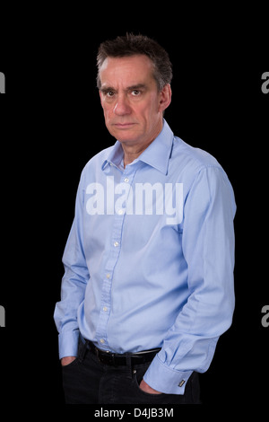 Wütend stirnrunzelnd Mittelalter Business-Mann im blauen Hemd schwarzen Hintergrund Stockfoto