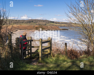 Walker, ein Spaziergang durch küssen Tor am Küstenweg über Traeth yr Ora Strand auf Isle of Anglesey Küste North Wales UK Großbritannien Stockfoto