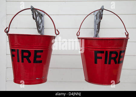 Alten Metallbrand Eimer hängen gegen eine weiße Holzwand Stockfoto