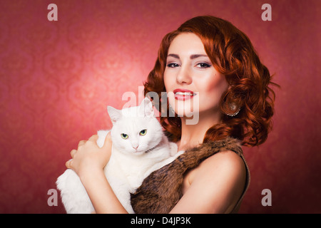 rote wunderschöne Mädchenmode mit weiße flauschige Katze Stockfoto