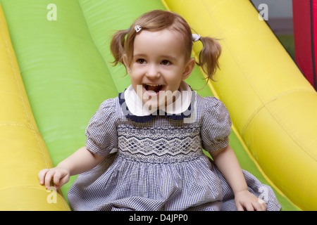 kleines Mädchen auf Spielplatz Folie lacht Stockfoto