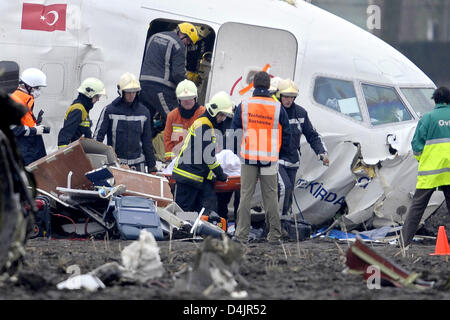 Eine Leiche wird aus dem Wrack des abgestürzten Flugzeugs liegt in einem Feld in Amsterdam, Niederlande, 25. Februar 2009 gewonnen. Das Flugzeug von Turkish Airways hat bei der Landung in Amsterdam abgestürzt? s Schiphol Flughafen, neun Menschen getötet und mehr als 50 der 134 Passagiere verletzen. Die Gründe für den Absturz sind noch unklar. Foto: Achim Scheidemann Stockfoto