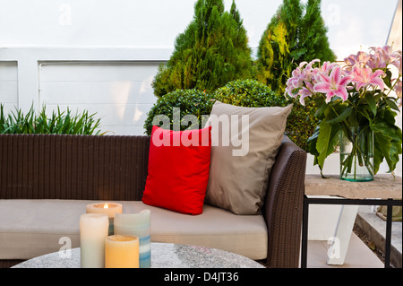 Terrasse, Sitzecke mit schönen Rattan Sofa bei Sonnenuntergang Stockfoto