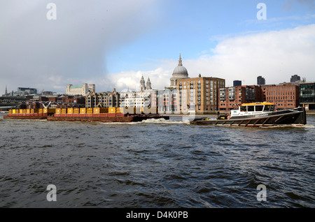 Cory Umweltschlepper „Recovery“ zieht einen Lastkahn auf der Themse. London, Großbritannien. Flussverkehr für Unternehmen, Industrie. Skyline von London Stockfoto