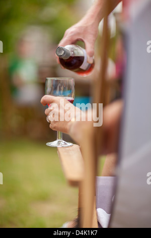 Frau Glas Wein im freien gießen Stockfoto