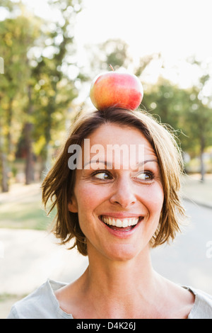 Frau balancieren Apfel auf den Kopf im freien Stockfoto