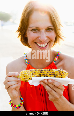 Frau Essen Mais auf die Cob-Natur Stockfoto