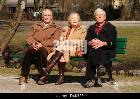 Rentner Theodor Ziegler (L-R), Elisabeth Ziegler und Horst Hoerhager sitzen in der Sonne auf einer Parkbank im englischen Garten in München, Deutschland, 18. März 2009. Sie genießen den schönen Frühlingstag. Foto: Felix Hoerhager Stockfoto