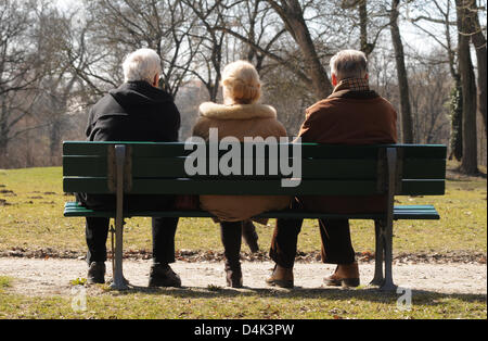 Rentner Horst Hoerhager (L-R), Elisabeth Ziegler und Theodor Ziegler sitzen in der Sonne auf einer Parkbank im englischen Garten in München, Deutschland, 18. März 2009. Sie genießen den schönen Frühlingstag. Foto: Felix Hoerhager Stockfoto