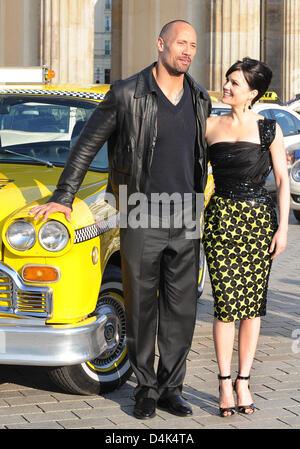 US-Schauspieler Dwayne Johnson (L) und Schauspielerin Carla Gugino stellen neben ein Original? Yellow Cab? während des Telefonats Foto anlässlich der bevorstehenden Deutschland-Premiere ihres Films? Race to Witch Mountain? vor dem Brandenburger Tor in Berlin, Deutschland, 31. März 2009. Der Film werden in den deutschen Kinos ab 9. April 2009. Foto: Jens Kalaene Stockfoto