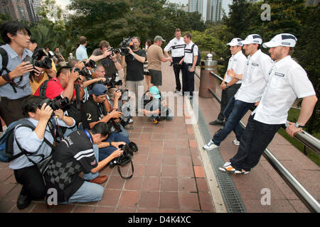 Deutsche Formel1-Fahrer Nick Heidfeld (R-L), polnischer Formel-1-Pilot Robert Kubica und österreichischen Testfahrer Christian Klien von BMW Sauber posieren vor den Petronas Towers in Kuala Lumpur City Centre (KLCC) in Kuala Lumpur, Malaysia, 1. April 2009. Am 5. April 2009 wird der Formel 1 Grand Prix von Malaysia in Sepang Circuit nahe Kuala Lumpur stattfinden. Foto: JENS BUE Stockfoto