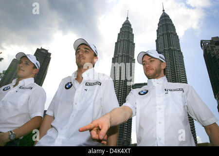 Deutsche Formel1-Fahrer Nick Heidfeld (R-L), polnischer Formel-1-Pilot Robert Kubica und österreichischen Testfahrer Christian Klien von BMW Sauber posieren vor den Petronas Towers in Kuala Lumpur City Centre (KLCC) in Kuala Lumpur, Malaysia, 1. April 2009. Am 5. April 2009 wird der Formel 1 Grand Prix von Malaysia in Sepang Circuit nahe Kuala Lumpur stattfinden. Foto: JENS BUE Stockfoto