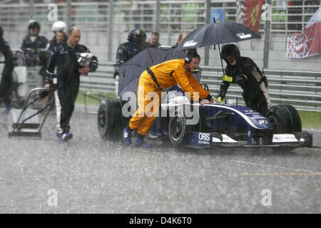 Williams F1 Mechanik zurückschieben den Rennwagen der japanischen Formel1-Fahrer Kazuki Nakajima als Grand Prix von Malaysia unterbrochen wurde durch Starkregen auf Sepang außerhalb Kuala Lumpur, Malaysia, 5. April 2009. Foto: JENS Büttner Stockfoto