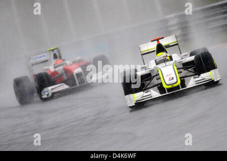 Britische Formel1-Fahrer Jenson Button des Brawn GP (R) führt vor fo Deutschland? s Timo Glock Toyota während des Grand Prix von Malaysia in Sepang Circuit außerhalb Kuala Lumpur, Malaysia, 5. April 2009. Button gewann das Rennen vor deutschen Formel1-Fahrer Nick Heidfeld BMW Sauber und Glock. Das Rennen war nach 31 Runden wegen Starkregen rot gekennzeichnet. Foto: Peter Steffen Stockfoto