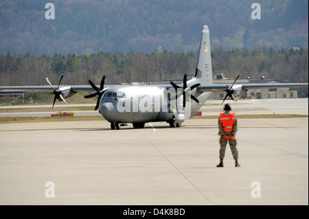 Ein Mitglied des Bodenpersonals leitet eines der neuen Art des Transports Flugzeuge? Lockheed Martin C-130J Super Hercules? um seine Parkposition bei der US Air Force Base in Ramstein, Deutschland, 7. April 2009. Das Flugzeug ist eines von insgesamt 14 Super Hercules ersetzen 86th Airlift Wing? s alte C-130E Hercules-Flugzeuge. Foto: HARALD TITTEL Stockfoto
