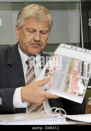 Führer der deutschen nationalen demokratischen Partei NPD, Udo Voigt, wirft einen Blick auf seine Dokumente in einem Gerichtssaal des Bezirksgerichts in Berlin, Deutschland, 16. April 2009. Der Prozess gegen Voigt und zwei weitere Vorstandsmitglieder der rechtsextremen NPD für Demagogie und Beleidigung wird fortgesetzt. Die Angeklagten werden beschuldigt, nach Veröffentlichung eines rassistischen Zeitplans für den FIFA World Cup Stockfoto